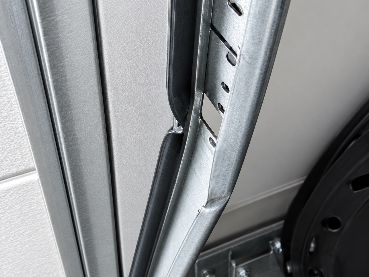 Bent section of garage door track beside the door