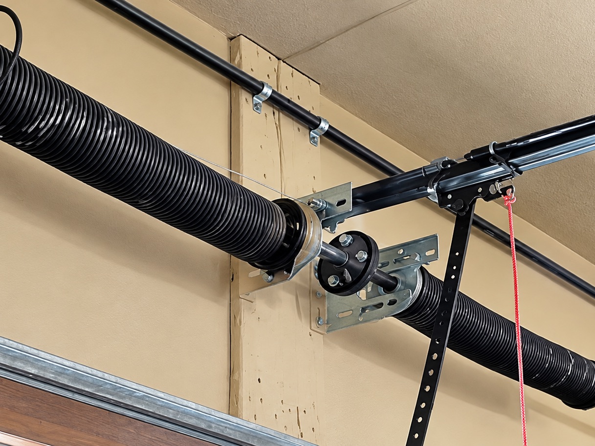 Torsion springs and cable drum on the shaft above a garage door